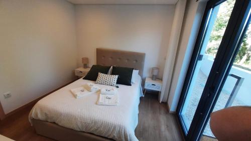 a bedroom with a bed with two towels on it at Casas Peralta - Outeiro in Arouca