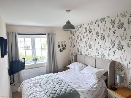 a bedroom with a bed with a floral wallpaper at Paddys Corner in Filey