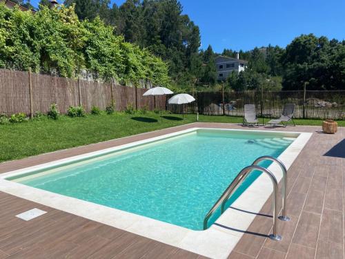 a swimming pool with a slide in a backyard at Casas Peralta - Outeiro in Arouca