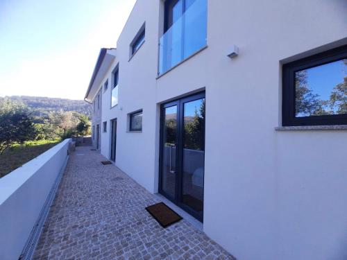 a hallway of a white building with a walkway at Casas Peralta - Outeiro in Arouca