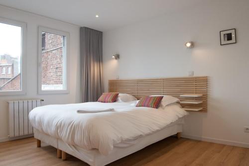 une chambre avec un grand lit blanc avec deux oreillers dans l'établissement La Maison sur le Toit, Hypercentre, Terrasse, Soleil, à Lille