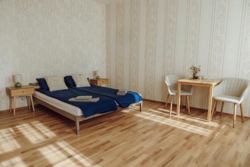 a bedroom with a bed and a table and chairs at Telegrāfs Hotel in Ventspils