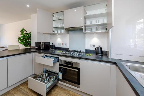 a kitchen with white cabinets and a stove top oven at My Chester Luxury Home in Colchester