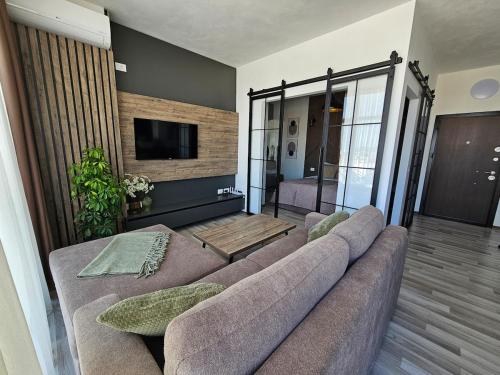 a living room with a couch and a flat screen tv at Luxury Penthouse with Private Jacuzzi & Sea View in Durrës