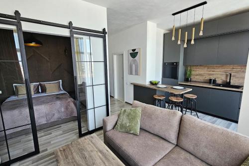 a living room with a couch and a bed and a kitchen at Luxury Penthouse with Private Jacuzzi & Sea View in Durrës