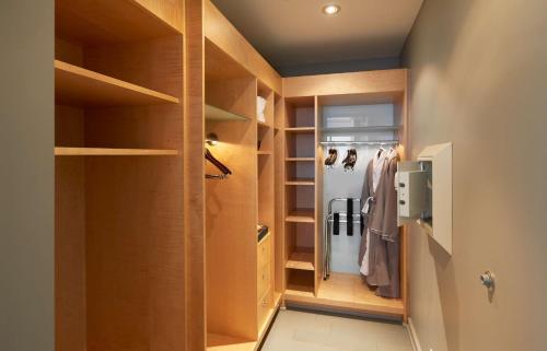 a walk in closet with wooden cabinets and shelves at The Lofton Hotel Minneapolis, Tapestry Collection by Hilton in Minneapolis