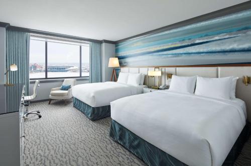 a hotel room with two beds and a window at The Lofton Hotel Minneapolis, Tapestry Collection by Hilton in Minneapolis