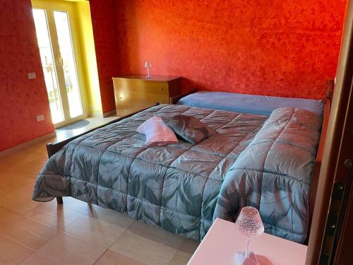 a bedroom with a bed in a red wall at Casa delle Fate in Gallo