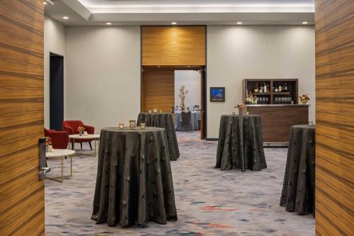 a room with tables and chairs and a bar at The Lofton Hotel Minneapolis, Tapestry Collection by Hilton in Minneapolis