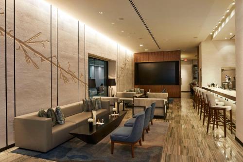 a hotel lobby with couches and chairs and a television at The Lofton Hotel Minneapolis, Tapestry Collection by Hilton in Minneapolis