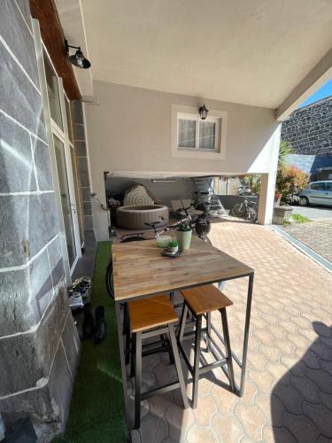 d'une terrasse avec une table en bois et 2 chaises. dans l'établissement My little cocon, à Aubière