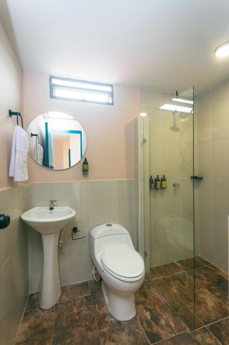 a bathroom with a toilet and a sink and a shower at Del Trópico Hotel By GyC Hotels in Sopetrán
