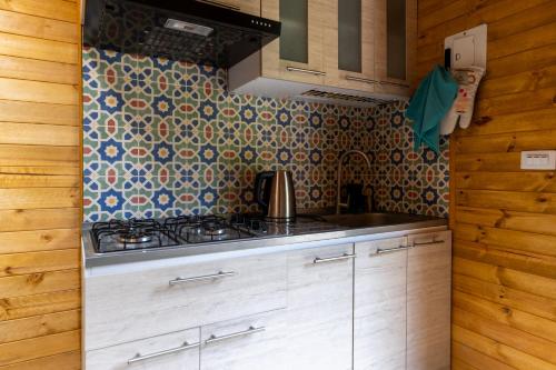 a kitchen with a stove and a tile wall at KITE KIWE LODGE - Parque Arvi in Guarne