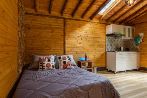 a bedroom with a bed in a wooden cabin at KITE KIWE LODGE - Parque Arvi in Guarne