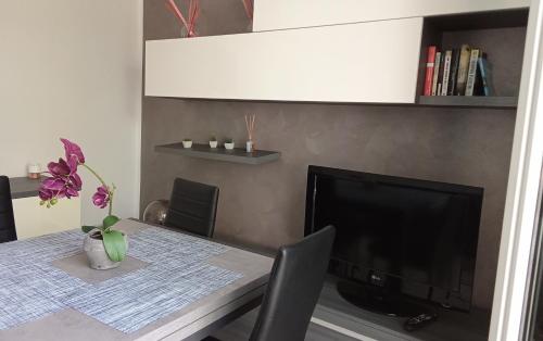 une salle à manger avec une table et une télévision dans l'établissement Apartment, Marina di Ravenna, à Marina di Ravenna