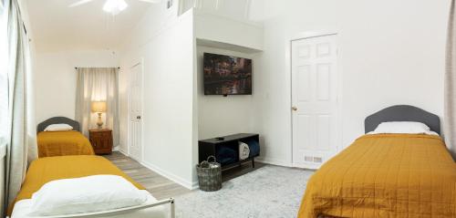 two beds in a room with white walls at 4-BD 3-FullBA SAMedical Cen,Riverwalk,Fiesta,Rodeo in San Antonio