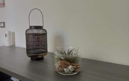 une lampe et un vase en verre sur une table dans l'établissement Apartment, Marina di Ravenna, à Marina di Ravenna