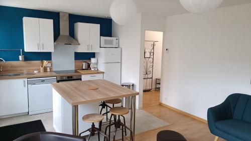une cuisine avec une table et des tabourets dans une pièce dans l'établissement Maison de plein pied avec jardin, à Poitiers