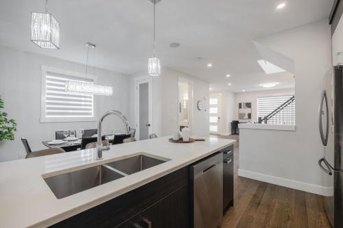 eine Küche mit Spüle und Arbeitsplatte in der Unterkunft Home Theater with AC, Dual Master Suites, BBQ in Calgary