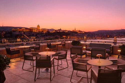 a rooftop patio with tables and chairs at sunset at Budapest Marriott Hotel in Budapest