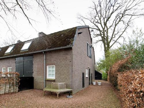 a brick house with a bench in front of it at Cottage in Leenderbos near Nature Reserve in Leende