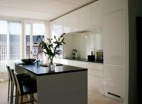 a kitchen with white cabinets and a black counter top at Thorshavnsgade Apartment in Copenhagen