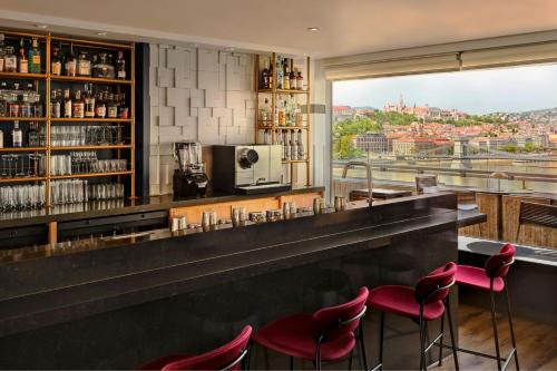 a bar with red chairs and a view of the city at Budapest Marriott Hotel in Budapest