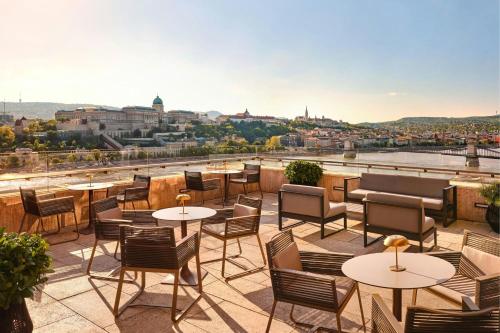 a patio with tables and chairs and a view of the city at Budapest Marriott Hotel in Budapest