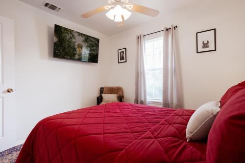 a bedroom with a red bed with a ceiling fan at 4-BD 3-FullBA SAMedical Cen,Riverwalk,Fiesta,Rodeo in San Antonio