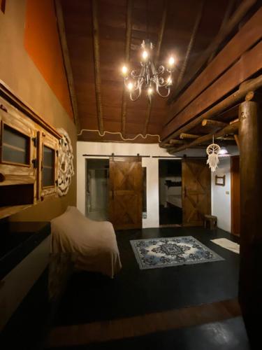 a bedroom with a bed and a chandelier at Chácara Namorada do Sol - Pousada e Camping in Guaxupé