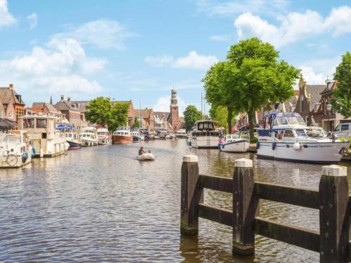 a river with boats and a couple of people in a boat at Villa by Tjeukemeer with Private Jetty in Delfstrahuizen