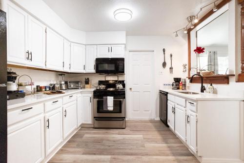 a white kitchen with white cabinets and appliances at 4-BD 3-FullBA SAMedical Cen,Riverwalk,Fiesta,Rodeo in San Antonio