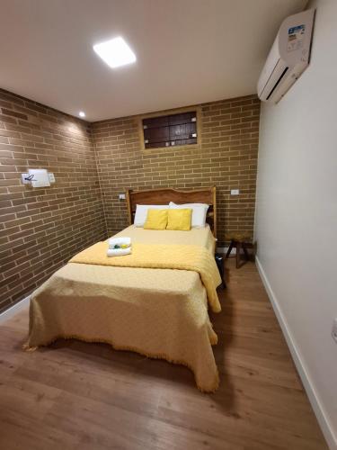 a bedroom with a bed and a brick wall at Flat 305 hotel Fazenda Engenho Pedra do Rodeadouro in Bonito