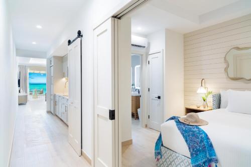 a bedroom with a bed and a view of the ocean at Windsong on the Reef in Grace Bay