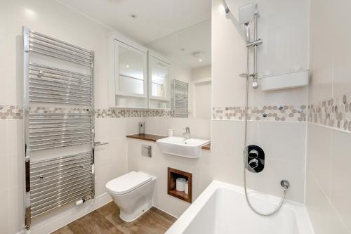 a white bathroom with a toilet and a sink at My Chester Luxury Home in Colchester