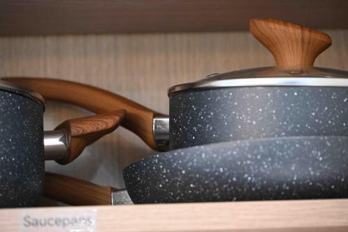 two pots sitting on top of a wooden shelf at Hidden Home in Haywards Heath