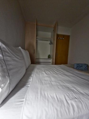 a large white bed in a room with a window at Quarto exclusivo, próximo a Dutra e Vale Sul Shopping em SJCampos-SP in São José dos Campos