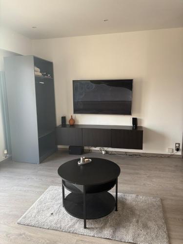 Il comprend un salon doté d'une table noire et d'une télévision à écran plat. dans l'établissement Beau studio climatisé très proche de la mer, à Cagnes-sur-Mer