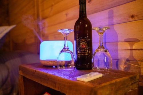 three wine glasses and a bottle on a table at KITE KIWE LODGE - Parque Arvi in Guarne