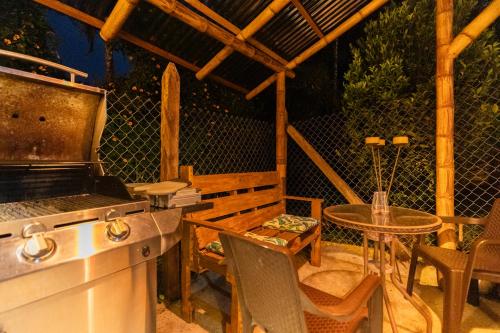 an outdoor kitchen with a table and a grill at KITE KIWE LODGE - Parque Arvi in Guarne