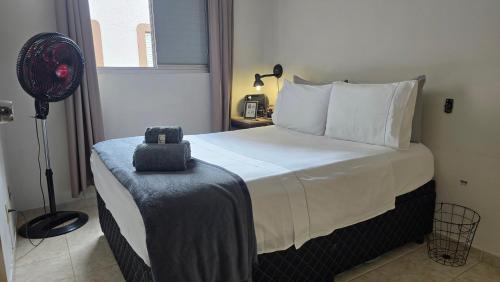 a bedroom with a large bed with a fan at Quarto exclusivo, próximo a Dutra e Vale Sul Shopping em SJCampos-SP in São José dos Campos