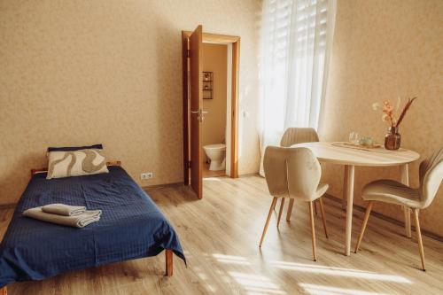 a bedroom with a bed and a table and chairs at Telegrāfs Hotel in Ventspils