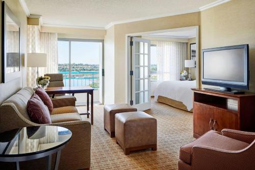 a large hotel room with a bed and a television at Newport Beach Marriott Bayview in Newport Beach