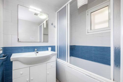Un baño con lavabo, bañera y espejo. en Villa Ginevra, en Son Bou