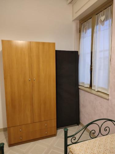 a large wooden cabinet sitting next to a window at Casa Martina in Torre San Giovanni Ugento