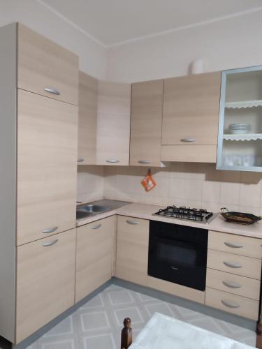a kitchen with white cabinets and a black oven at Casa Martina in Torre San Giovanni Ugento