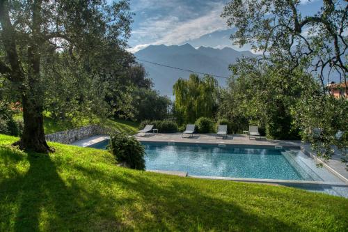 a swimming pool in a yard with mountains in the background at Villa Andreis in Malcesine