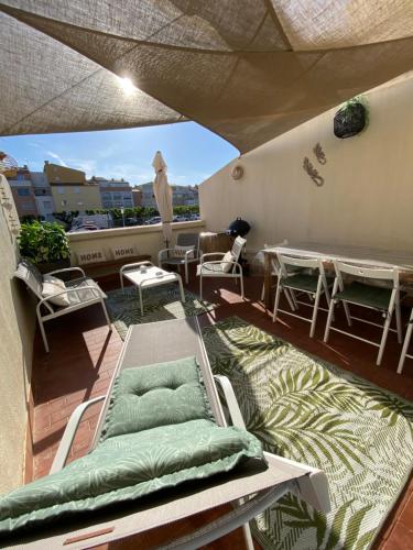 un balcon avec des chaises et des tables sur un toit dans l'établissement Studio entièrement rénové avec grande terrasse pour 4 personnes - Cap d'agde, au Cap d'Agde