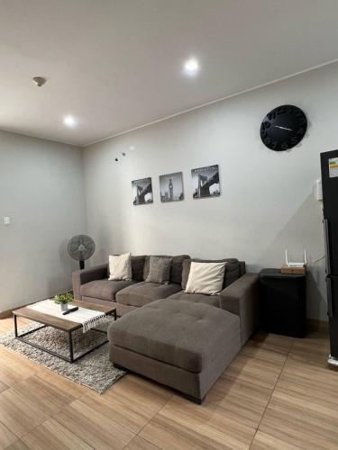 a living room with a couch and a table at Apartamento Miraflores country club in Piura