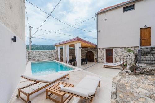 a patio with a swimming pool and a house at Villa Marisan in Bribir